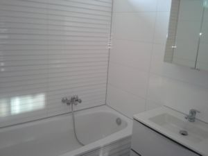 Badkamer met bad en wastafel, afgekit